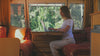 Woman sitting in a RV working on her laptop and looking outside