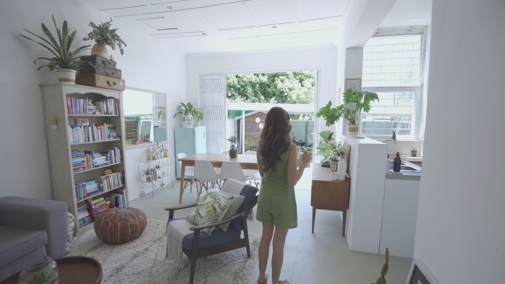 Video of a woman in her house watering her plants